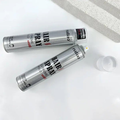 Two cans of hair spray with visible labels on a white surface.