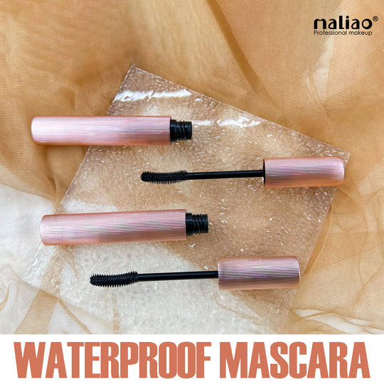 Two mascara tubes with black brushes on a transparent sheet against a beige fabric background, featuring the brand 'maliao'. maliao.pk