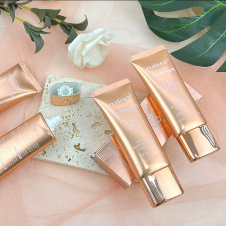 Gold-colored skincare products with 'nialuo' branding on a soft pink background with green leaves. maliao.pk